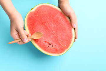 Half watermelon fruit holding by hand with spoon for eating on color background, Tropical fruit, Summer season