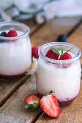 yoghurt with strawberries on wooden background
