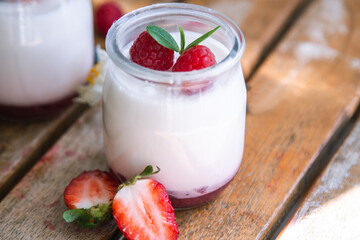 yoghurt with strawberries on wooden background