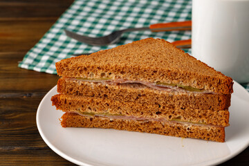Double club sandwich served on plate on wooden table