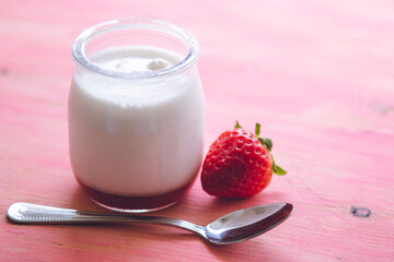 yogurt with strawberries on pink background