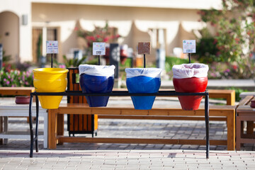 Clay pots of different colors with tables Paper, Plastic, Metal. Garbage sorting in one hotel of Egypt.