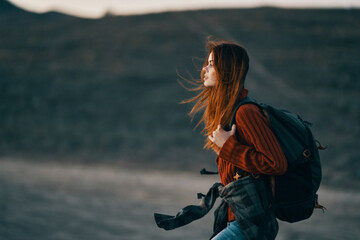 a woman in a theory family travels in nature in the mountains with a backpack on her shoulders