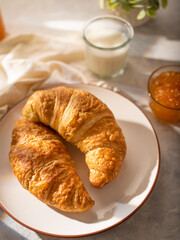 Morning breakfast. Croissants with coffee and jam. On a light table