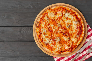 Tasty pizza on black wooden background top view
