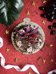 Black forest cake, dark chocolate  on a red textured background.