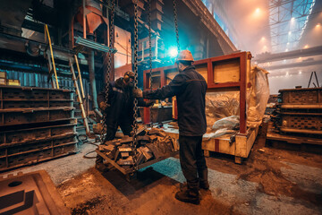 Heavy industry workers in steel mill foundry workshop interior, safety at work and teamwork in metalwork industry.