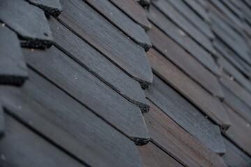 shingles on the roof. Wooden roof, shingled roof. Wooden tile. Roof of complex construction with...