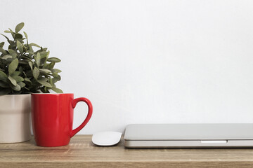 A mock up computer device with coffee cup and plant on table