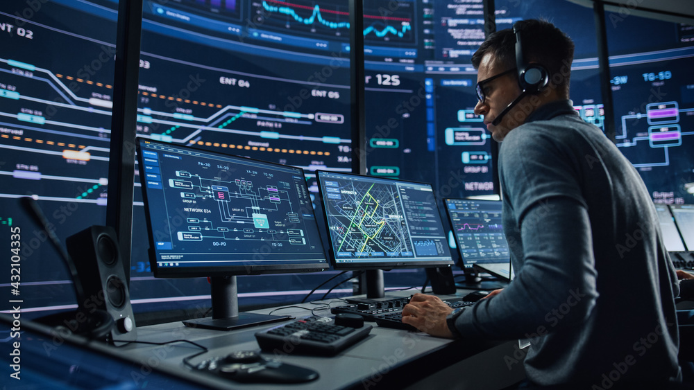 Poster Professional IT Technical Support Specialist and Software Developer Working on Computer in Monitoring Control Room with Digital Screens. Employee Wears Headphones with Mic and Talking on a Call.