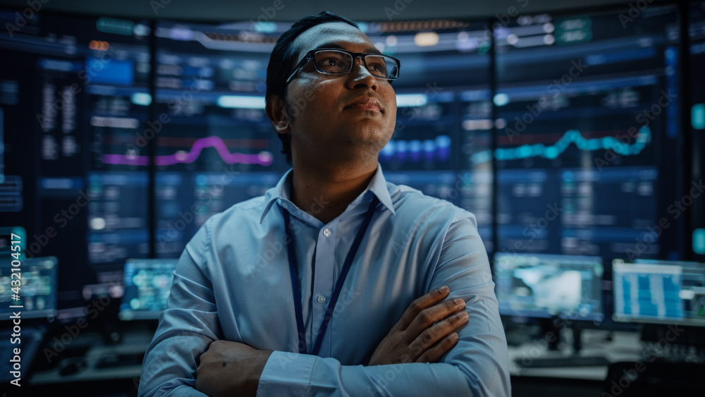 Poster Portrait of Professional Indian IT Technical Support Specialist or Software Developer Crossing Arms on Camera in a Modern Monitoring Control Room Full of Computer Displays with Technological Data.