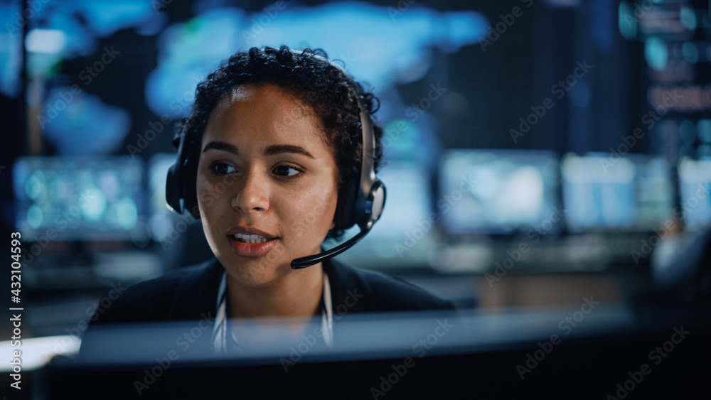 Aufkleber Portrait of Professional IT Technical Support Female Specialist Working on Computer in Monitoring Control Room with Digital Screens. Employee Wears Headphones with Mic and Talking on a Call.