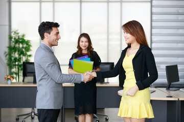 Success business deal agreement between Caucasian male businessman and Asian female businesswoman...