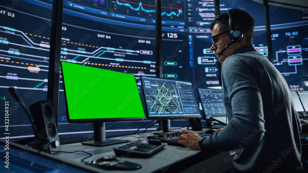 Aufkleber Professional IT Technical Support Specialist and Software Developer Working on Computer with Green Screen Mock Up Display in Monitoring Control Room with Digital Screens. Employee Wears Headphones.