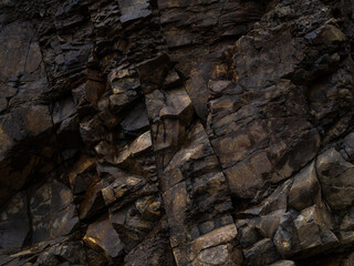 Black rock, stone, textured. Background for design. Hard light.