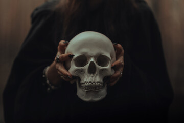 skull of a dead man in the hands of a witch witch