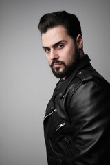 Bearded handsome spaniard man, posing on white wall. Vertical.