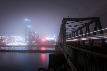Train bridge at a foggy night with light trail - obrazy, fototapety, plakaty