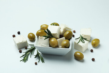 Bowl with feta, olives, rosemary and pepper on white background