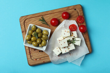 Concept of tasty food with feta cheese on blue background