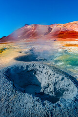 Geothermal active zone Hverir near Myvatn lake in Iceland, resembling Martian red planet landscape, at summer and blue sky