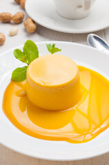 very tender sea buckthorn mousse on a white plate decorated with mint