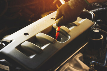 Mechanic hand is pulling oil dipstick to lube level checking of engine car