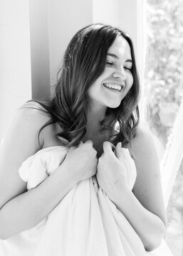 Portrait of a naked girl protecting her modesty with a duvet