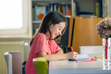 A young girl doing her homework at home during quarantine.