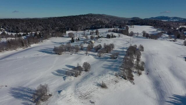 Aerial flyover snowy winter forest during Course Les Belle Combes Ski Race Competition in Jura,France.