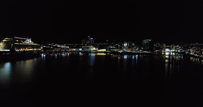 Aerial panorama view from illuminated Opera House by fjord to downtown city