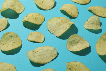 Potato chips on blue background, close up