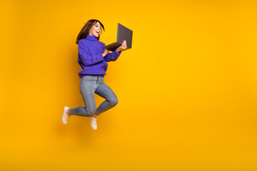 Photo of pretty cute young woman wear purple pullover jumping looking modern gadget empty space...
