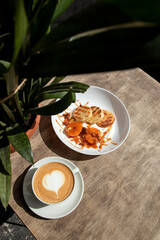 Cheese pancakes with cappuccino. Cheesecakes with tangerines and caramel.