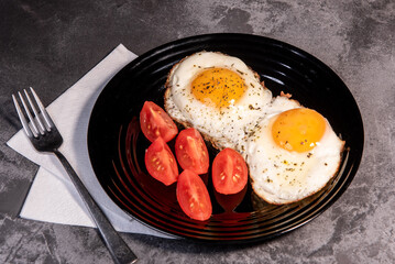 fried eggs and tomato slices, delicious breakfast, snack, yolk and protein food, background, top view, copy space, eat healthy raw materials. Scrambled eggs. Breakfast. Healthy eating. Close-up