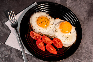 fried eggs and tomato slices, delicious breakfast, snack, yolk and protein food, background, top view, copy space, eat healthy raw materials. Scrambled eggs. Breakfast. Healthy eating. Close-up
