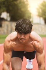 
a strong boy doing sports on a running track