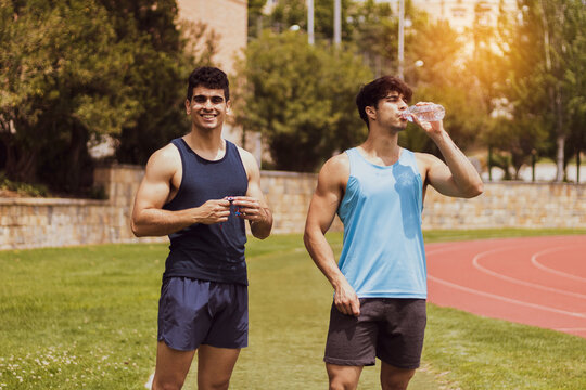 Two Strong Guys Posing On A Running Track