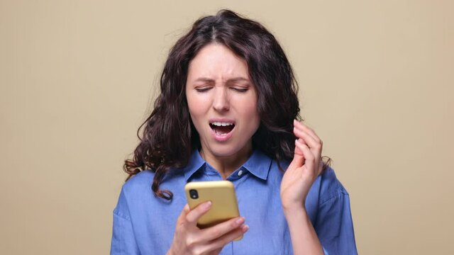 Stressed woman texting in smartphone send email to wrong recipient, get angry of bad news, message in social media. Shocked furious female reacting to unpleasant content on web, closeup studio shot