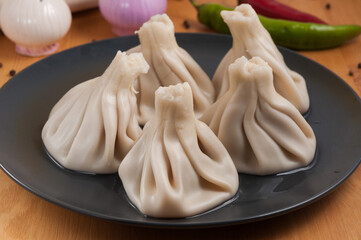 Georgian khinkali with chicken on a dark plate