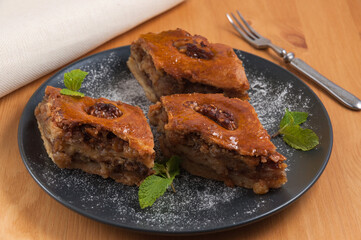 sweet Oriental dessert baklava with nuts on a dark plate