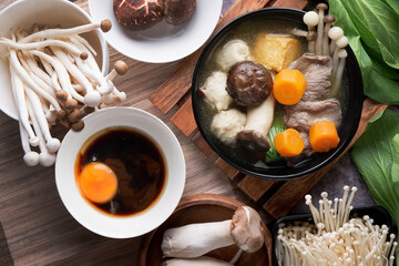 Hot pot with vegetables, mushrooms and tofu in wooden tray