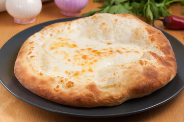 Khachapuri Megrelian Georgian cuisine on a dark plate