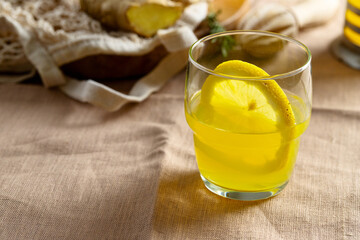 Close up of refreshment  lemonade glass on linen tablecloth. Summer beverage for hot day concept.