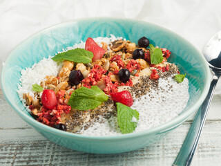 berry smoothie bowl in a blue plate on a wooden table