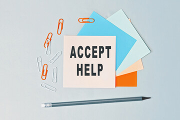 Accept Help - text on sticky note paper on gray background. Closeup of a personal agenda