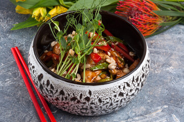 Kung pao chicken fillets in a bowl close up and rice. Horizontal