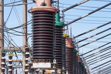 Fragment of a power plant. High-voltage equipment: a number of large insulators on the oil switch
