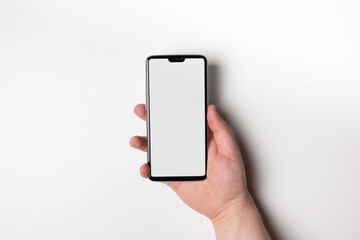 A phone with a white screen. Free space on the screen. The hand holds the phone vertically.