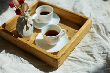 Breakfast in bed, try with two cups coffee and flower in sunlight at home